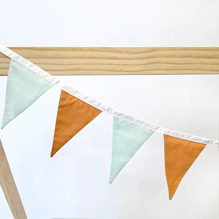 Bandeirola verde menta e laranja claro com fita off white na cama casinha